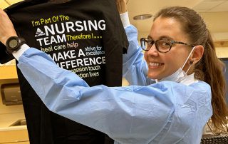 Nurse smiling holding shirt