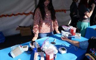 Blood pressure check at AHS tabling during Dia De Los Muertos event 2024.