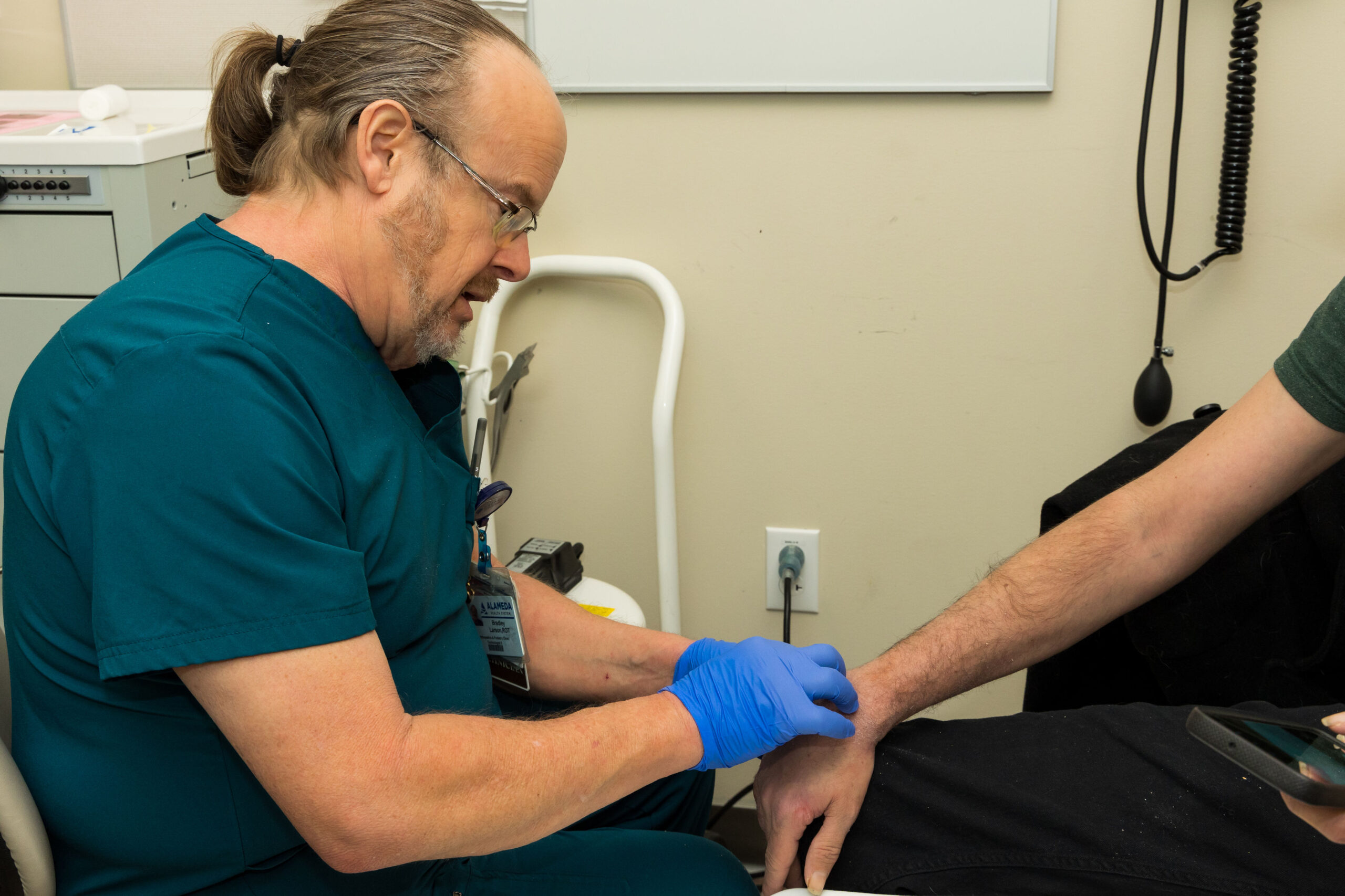 Ortho Surgeon examining patients hand.